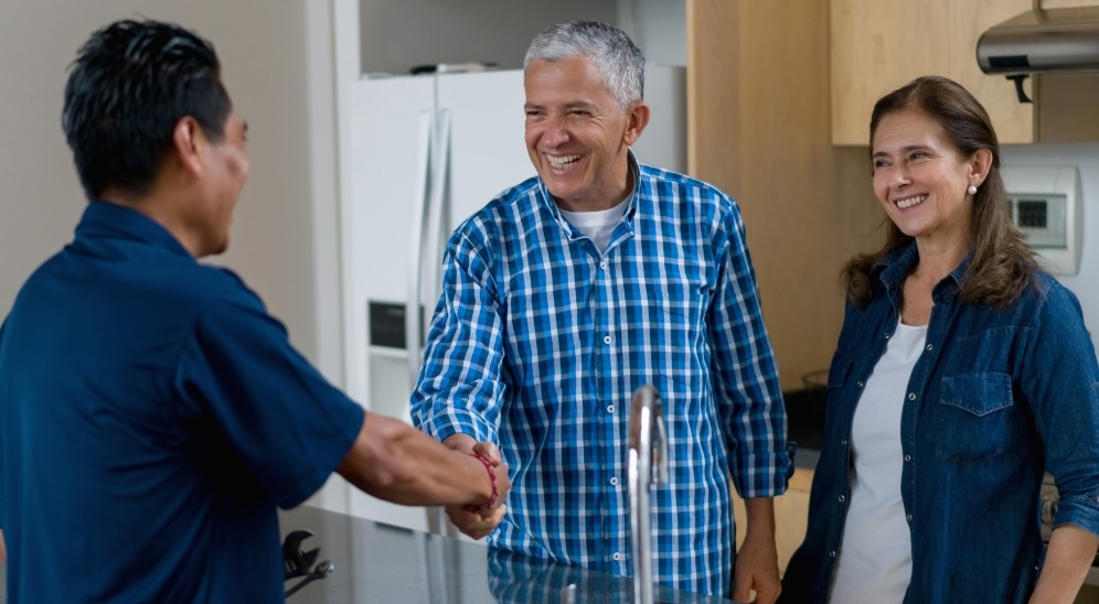 Technician shakes hands with customers.